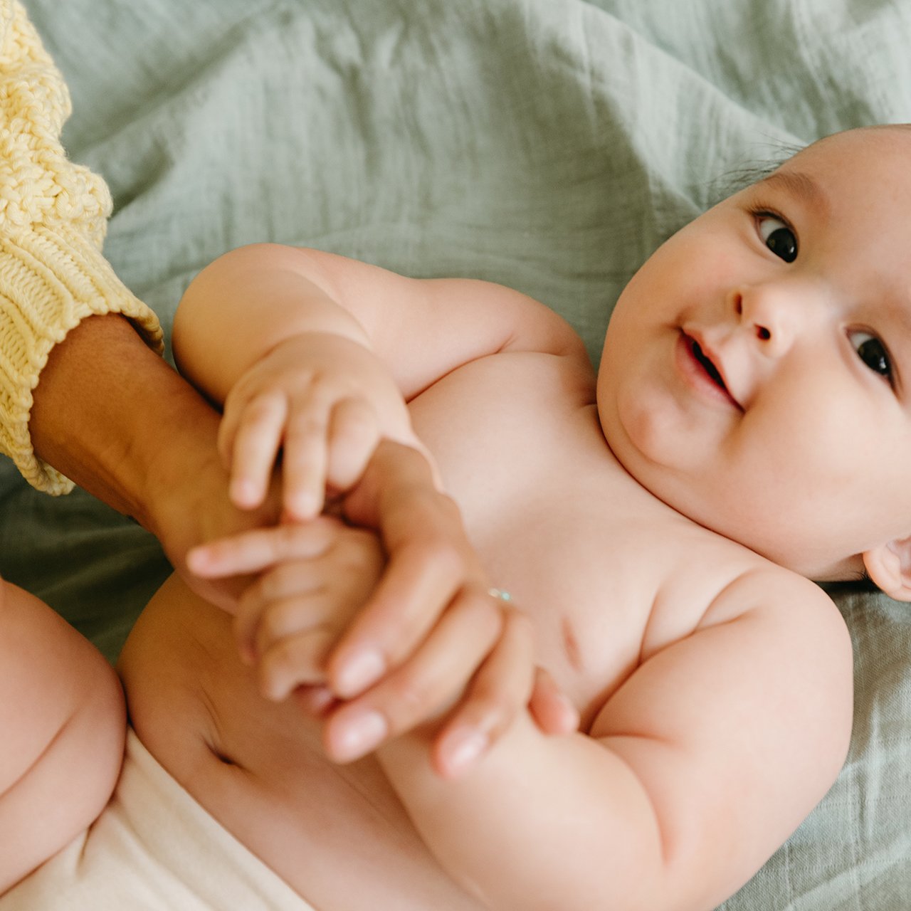 Baby lying down receiving a mother's massage